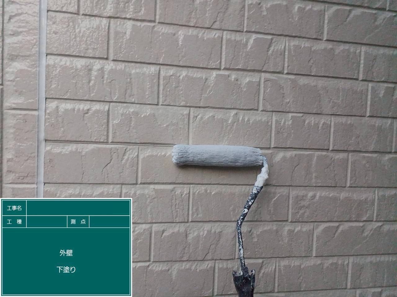 古くなったサイディングに下塗り材を塗装中